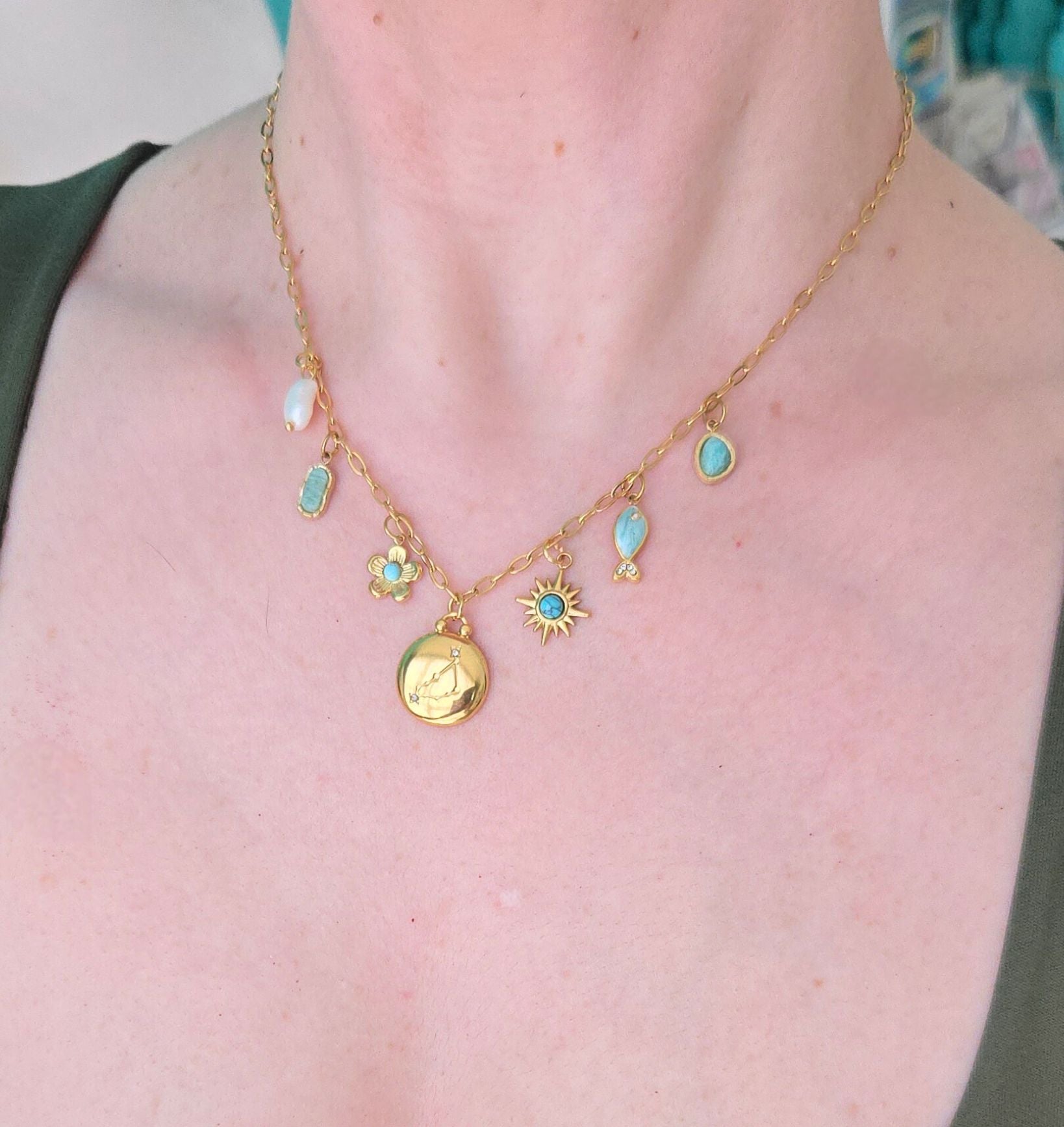 Gold necklace with various charms on a person's neck